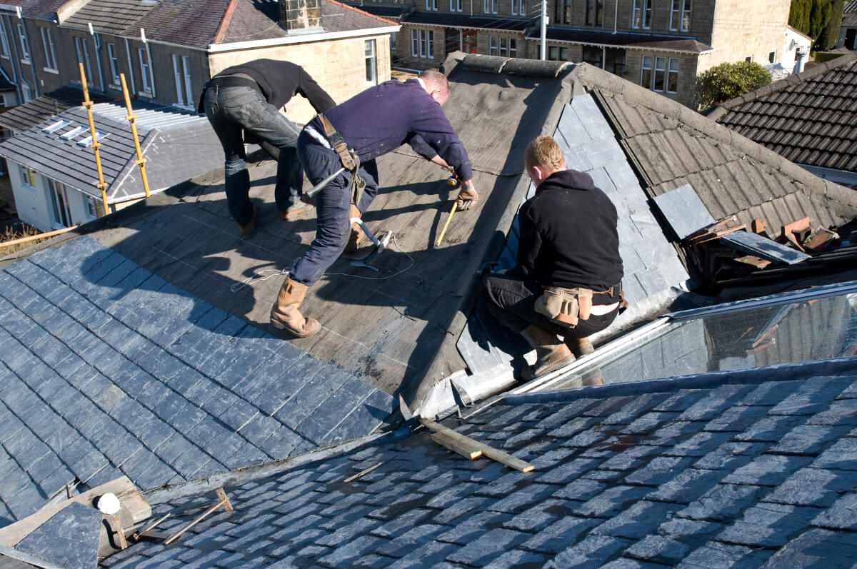 Professional roofer working on a house roof